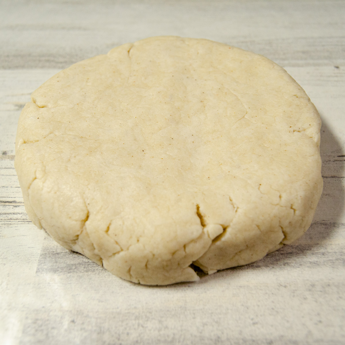 Flattened pie dough on a piece of waxed paper