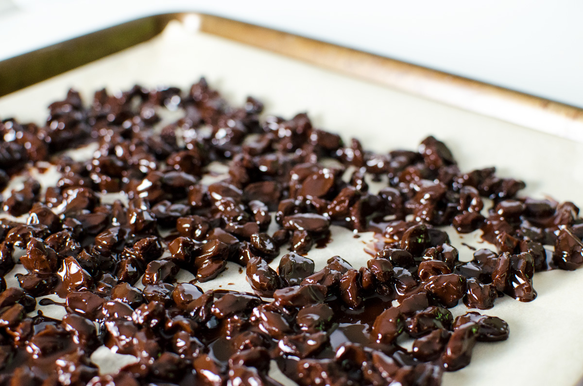 homemade chocolate covered raisins spread on parchment paper