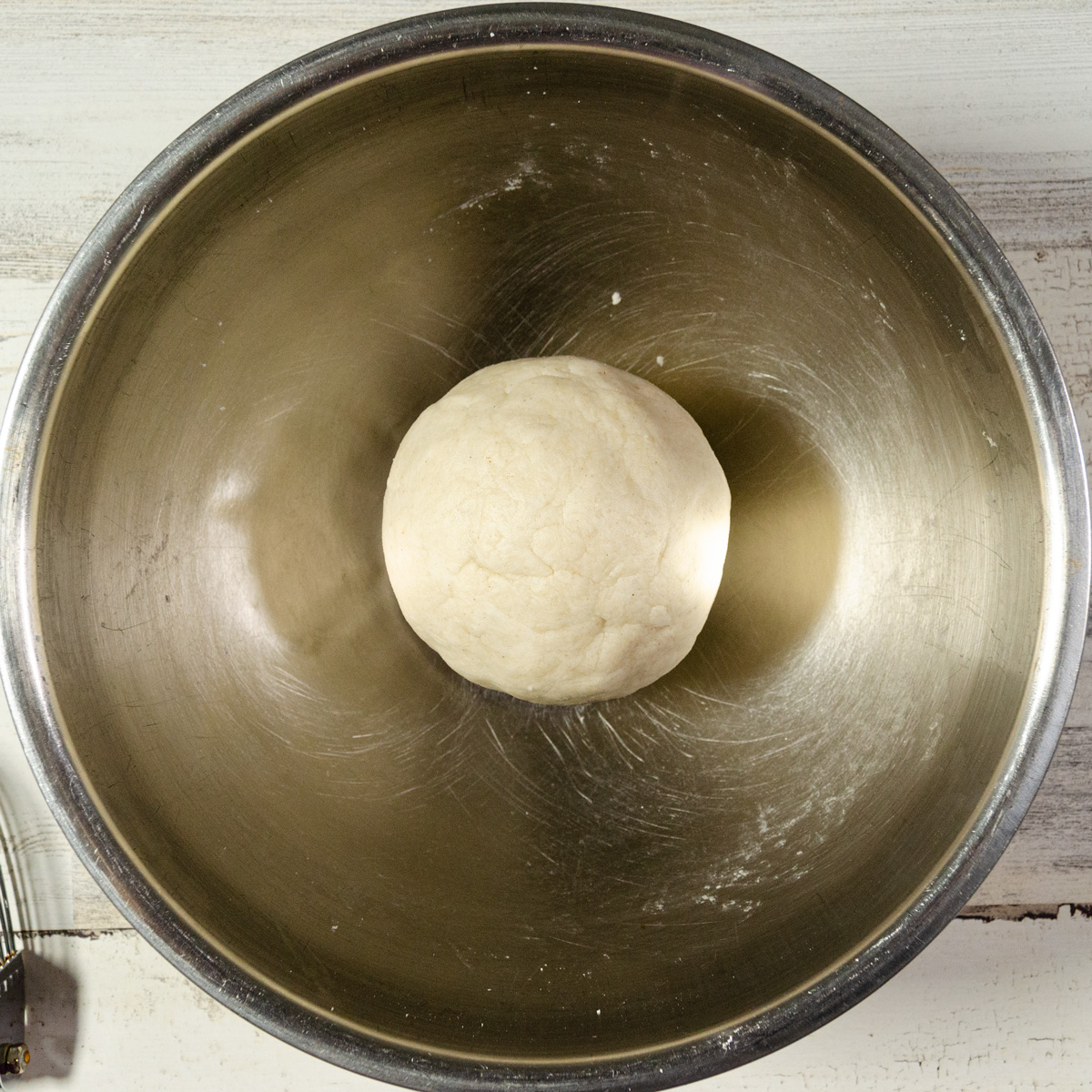 pie dough formed into a ball in a mixing bowl